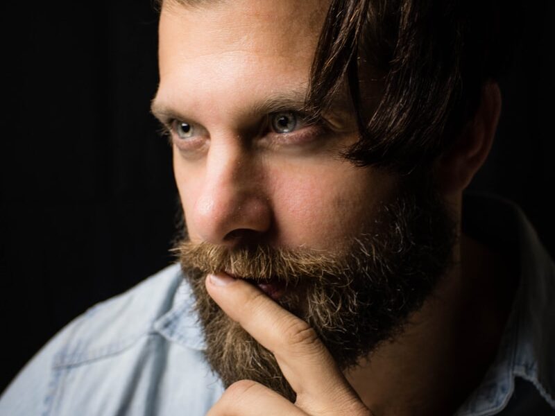man with index finger on lips