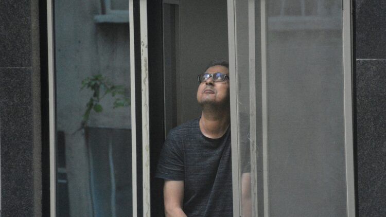a man looking out of a window in a building