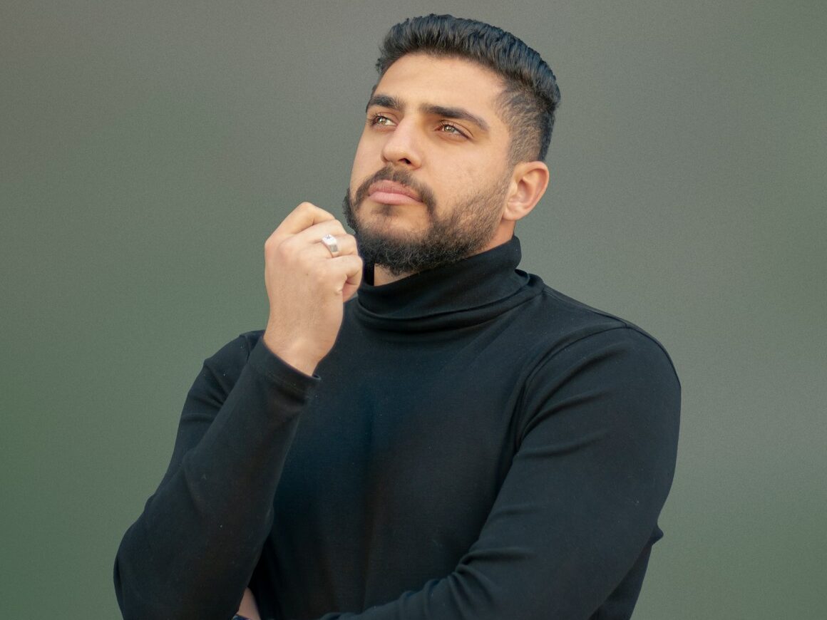 a man wearing a black turtle neck sweater