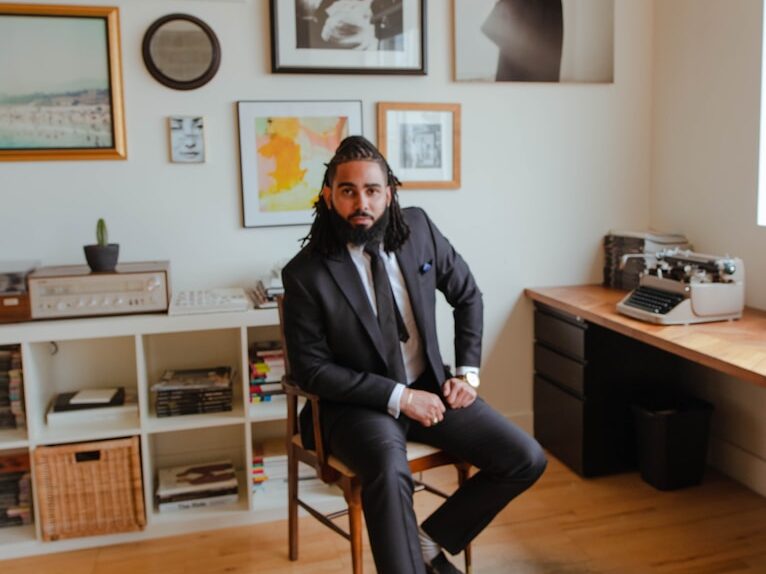 man in black jacket sitting on chair