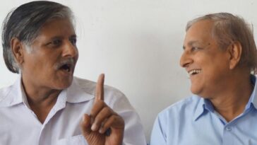 a person pointing at another man