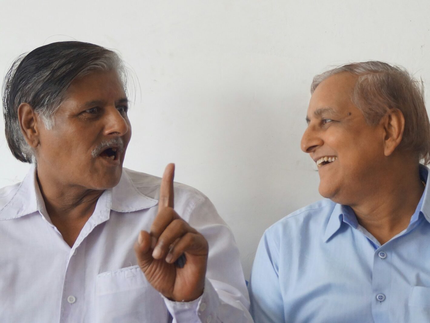 a person pointing at another man