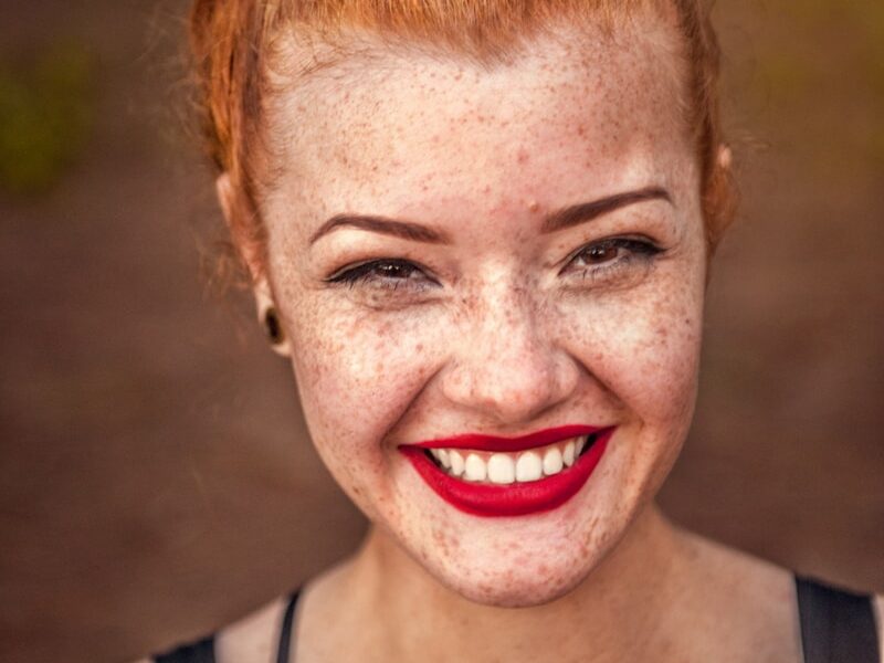 woman taking photo while showing smile