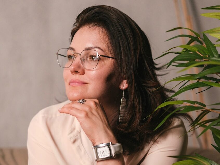 a woman wearing glasses sitting on a couch