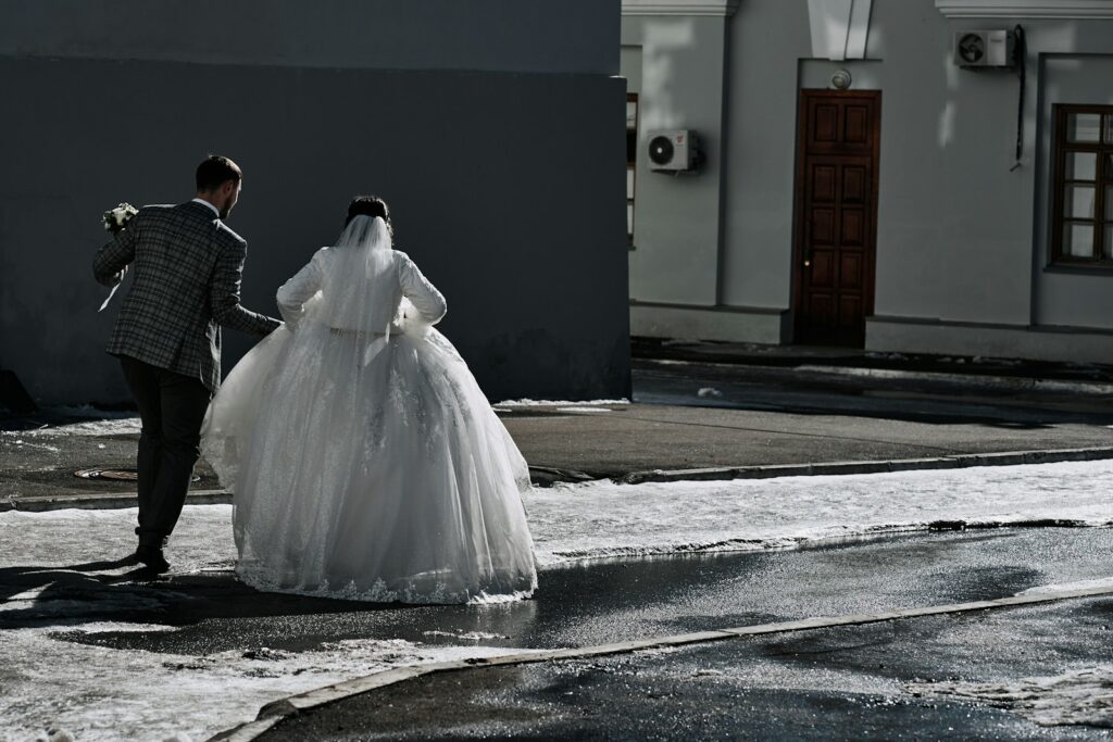a bride and groom walking down the street