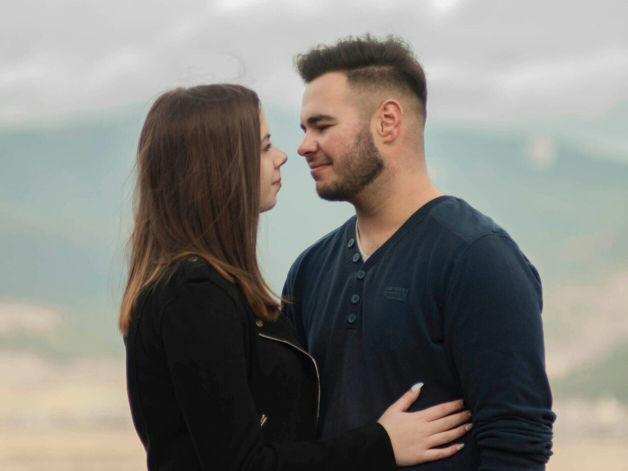 man in black long sleeve shirt kissing woman in black long sleeve shirt