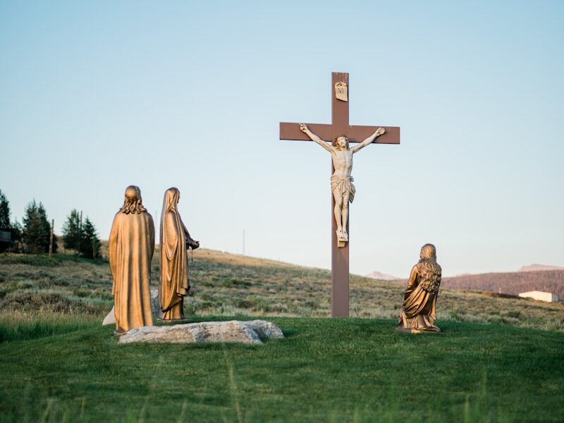 Crucifix statue on green grass