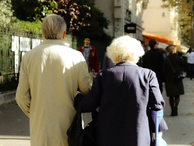 a couple of people walking down a sidewalk