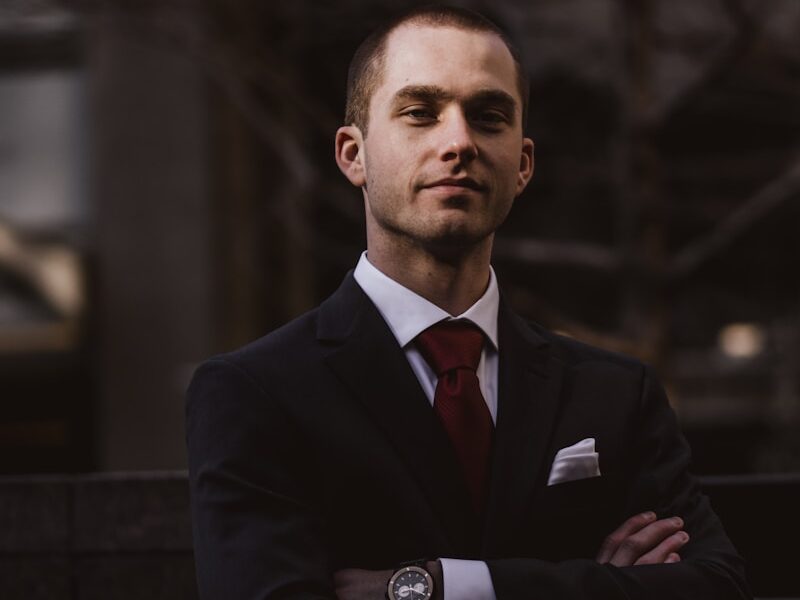man wearing black notched lapel suit jacket in focus photography