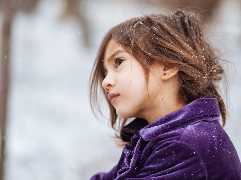 girl wearing purple jacket across blurry background