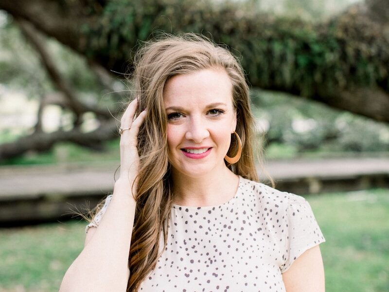 woman in white and black polka dot shirt smiling