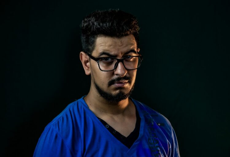 a man wearing glasses and a blue shirt