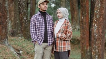 a man and a woman standing in the woods