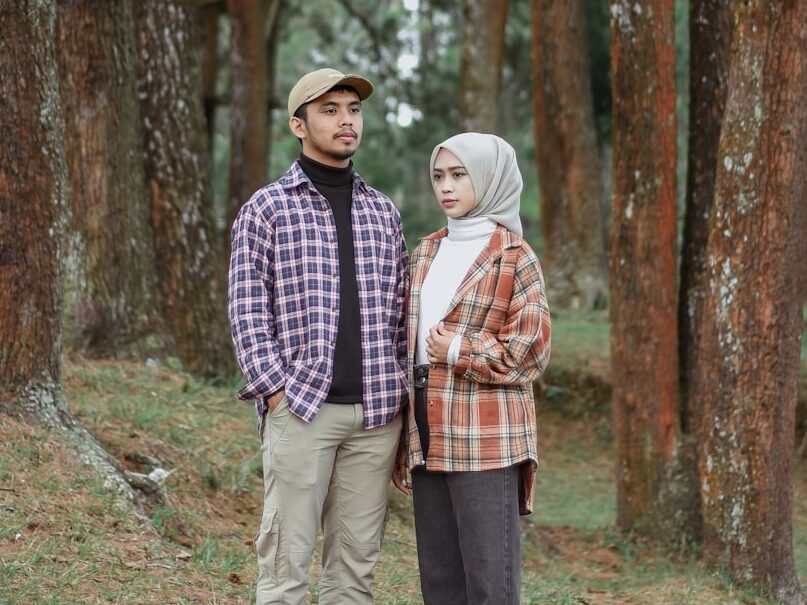 a man and a woman standing in the woods