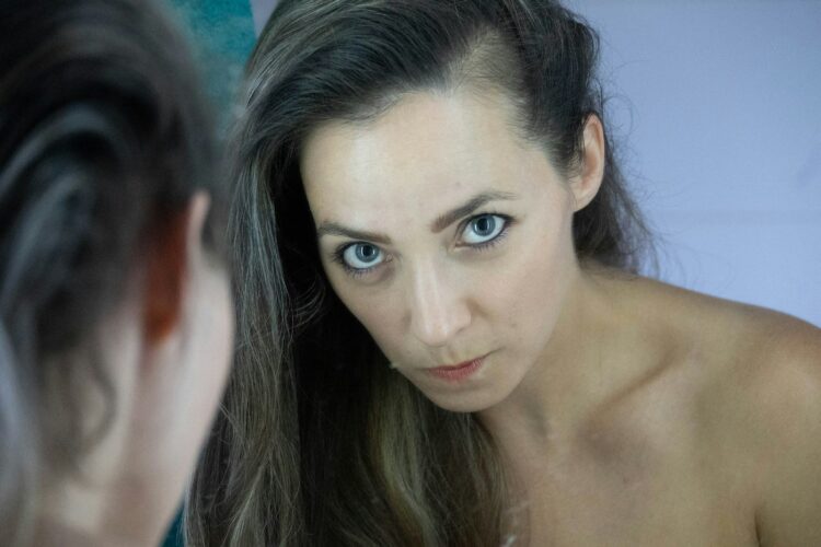 a woman looking at herself in the mirror