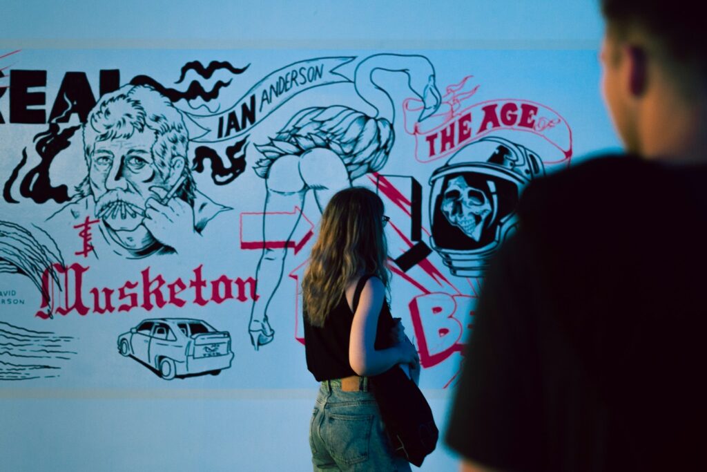a woman standing in front of a wall with a drawing on it