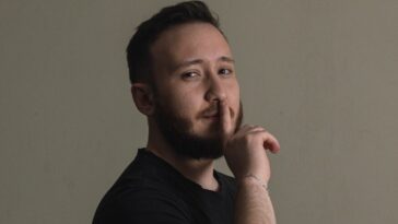 a man is posing for a picture with his hand on his chin
