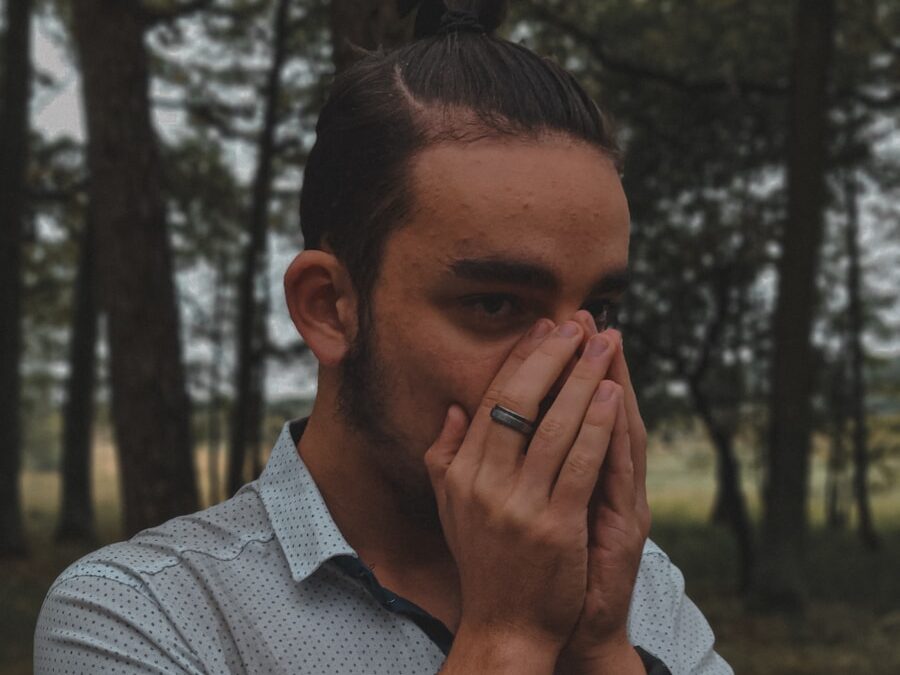 a man covers his face with his hands