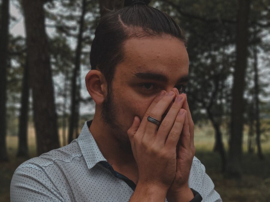 a man covers his face with his hands