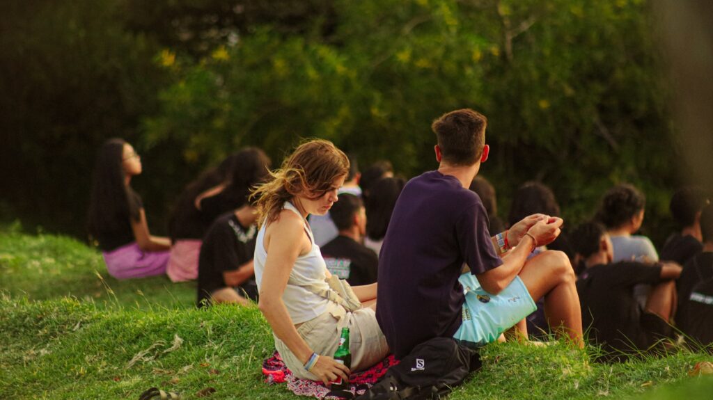 A group of people sitting in the grass