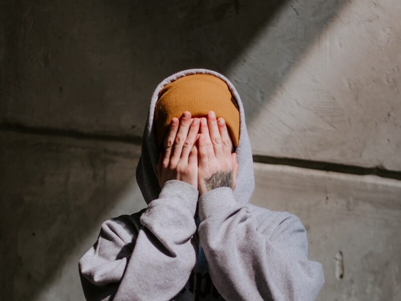 person in gray hoodie wearing brown leather shoes