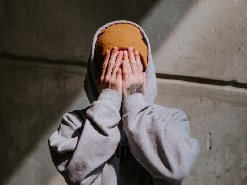 person in gray hoodie wearing brown leather shoes