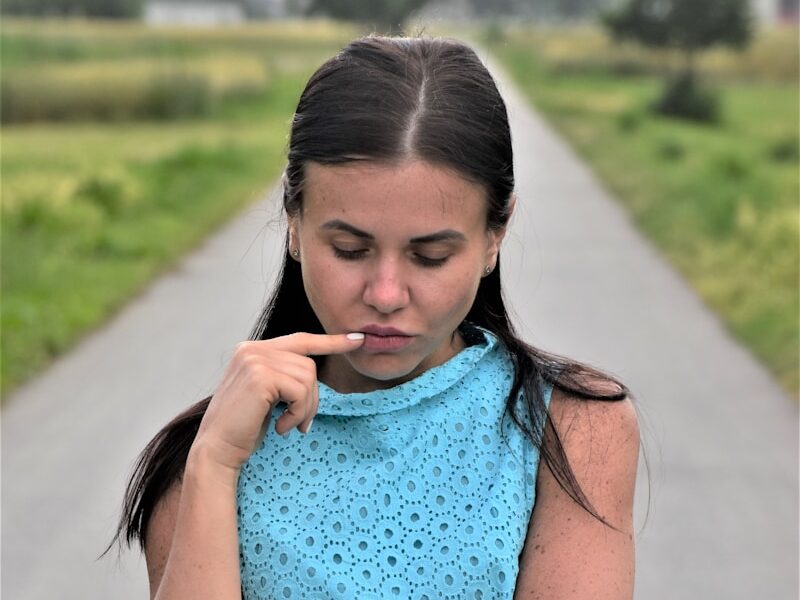 a woman in a blue dress holding a cigarette