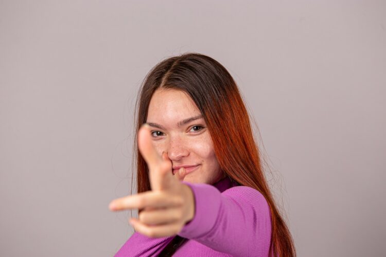 a woman pointing at the camera with her finger