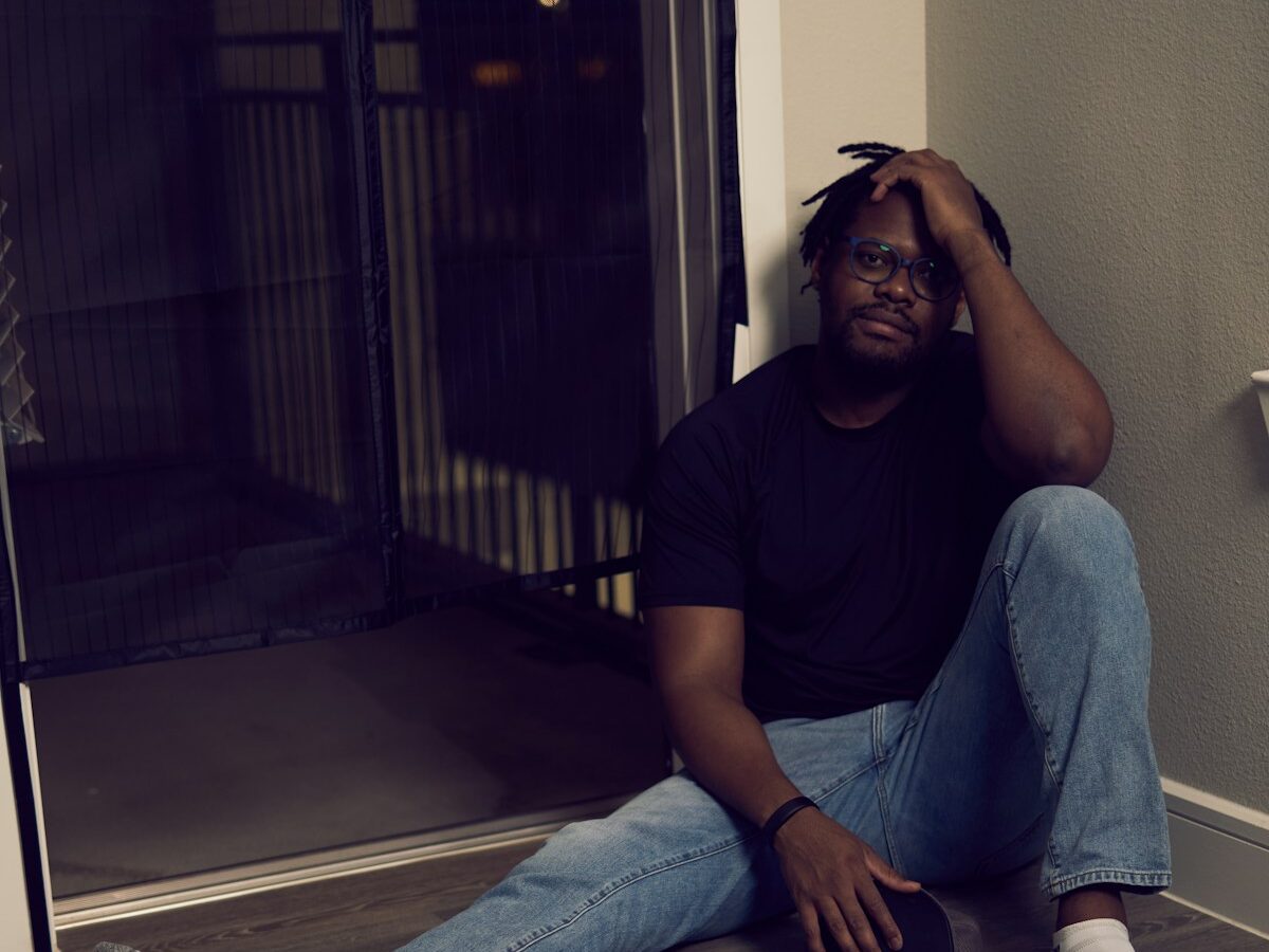 a man sitting on the floor with his head in his hands