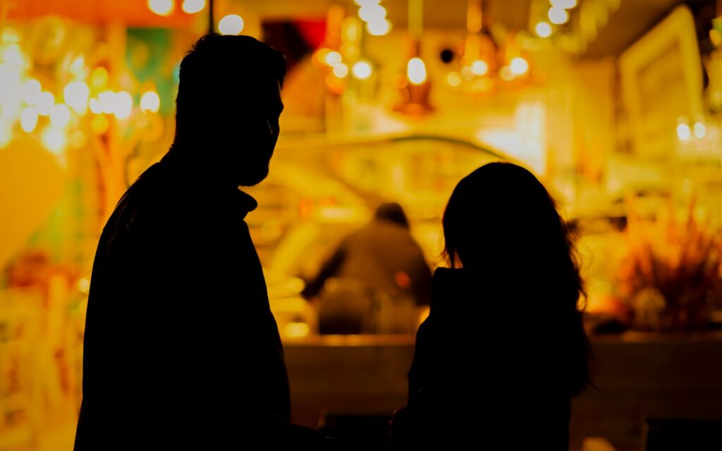 A man and a woman standing in front of a store