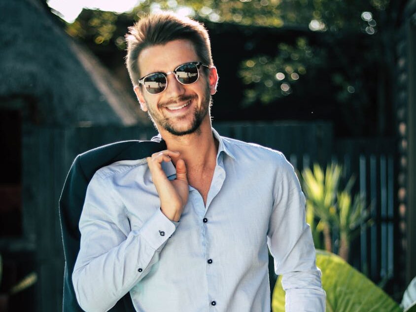 Confident young man in a stylish suit outdoors, exuding charm and elegance.