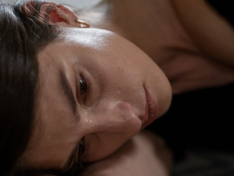 Close-up of a woman lying down, expressing sadness and crying.