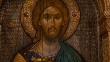 A classic Orthodox icon depicting Jesus Christ with an ornately carved frame in warm tones.