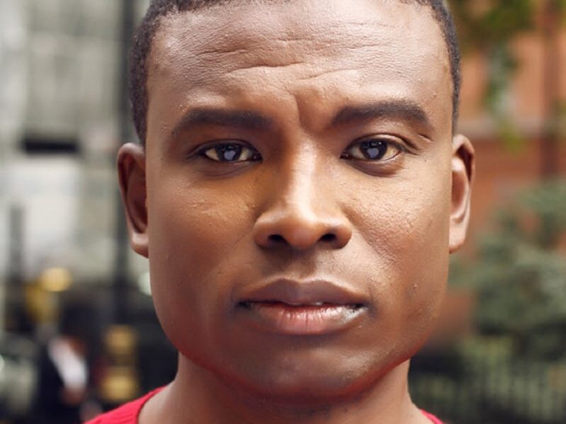 Close-up portrait of a man outdoors in Greater London, showcasing confidence and style.