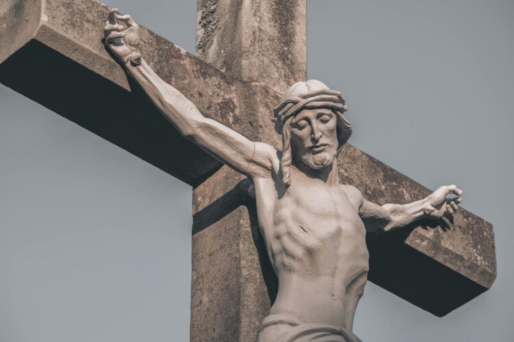 Close-up image of a crucifixion statue against a clear sky in Germany.