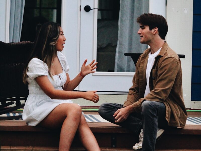 a man and woman sitting on a porch