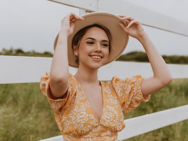 woman in brown floral crop top and blue denim shorts wearing brown hat