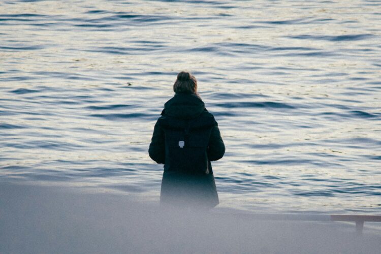a person standing in front of a body of water