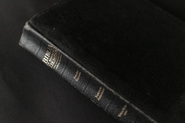 A black leather Bible with gold lettering on the spine, showcasing its textured cover.