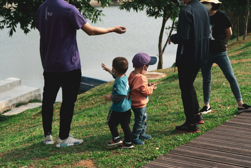 man in blue crew neck t-shirt and black pants holding girl in orange t-shirt