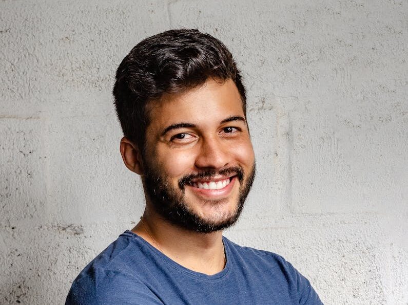 Portrait of a happy man with arms crossed, exuding confidence and friendliness.