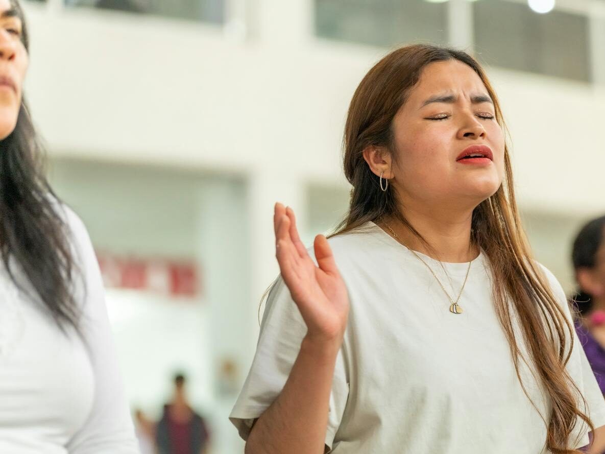 A woman deeply engrossed in prayer during a church gathering in Ciudad de México.