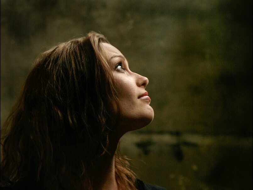 Elegant side profile of brunette woman looking upwards in a contemplative mood.