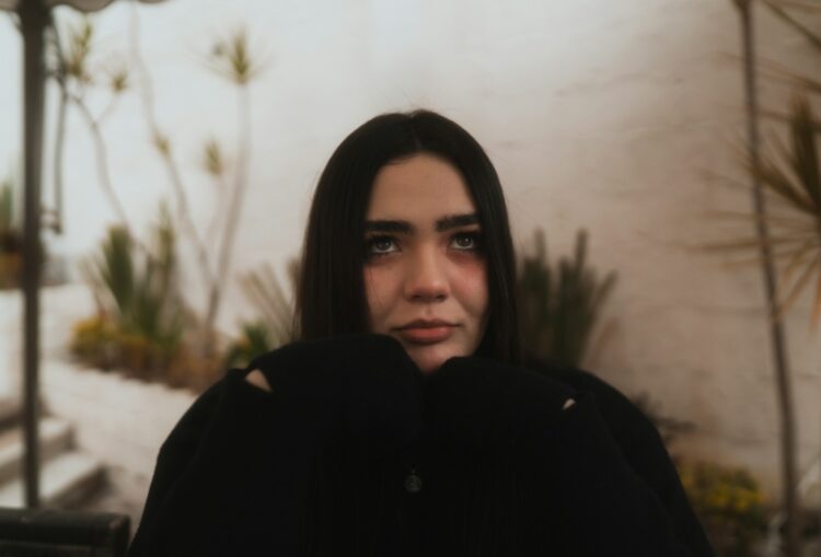 a woman in a black coat looking at the camera