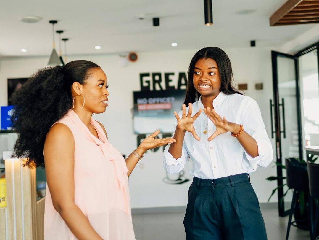 Two women engaging in a vibrant discussion at Café One in Lagos, Nigeria.