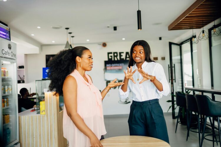 Two women engaging in a vibrant discussion at Café One in Lagos, Nigeria.