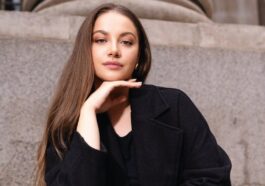 Elegant portrait of a confident woman sitting on steps in London, exuding style and grace.