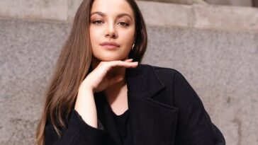 Elegant portrait of a confident woman sitting on steps in London, exuding style and grace.