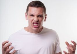 Angry young man clenching fists with a fierce expression. Studio portrait in Curitiba, Brazil.
