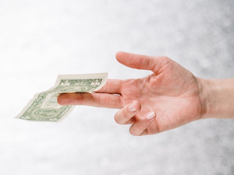 Close-up of a hand holding a one dollar bill, symbolizing finance or payment.